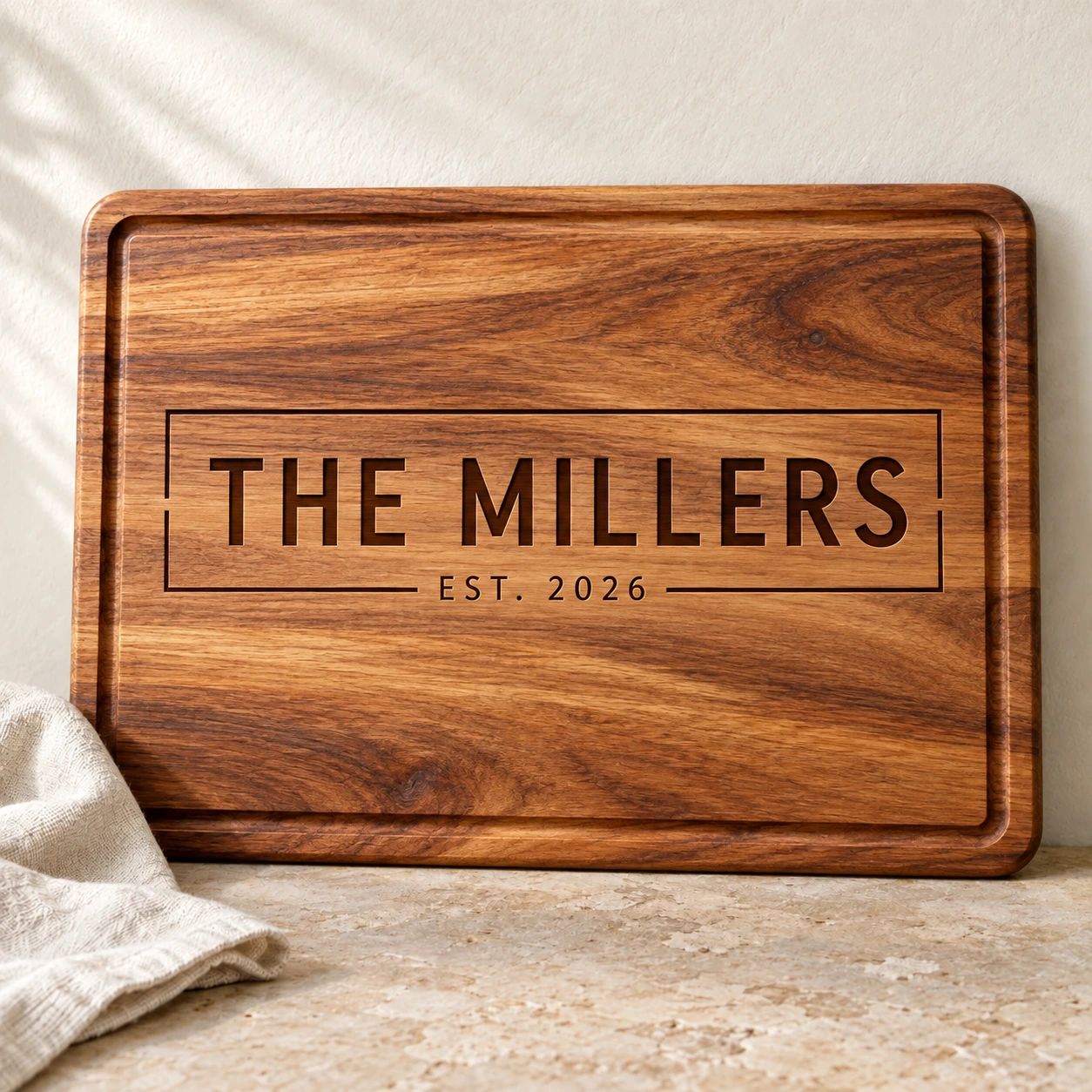 Large family-name engraving: Modern sans · geometric frame on Acacia.